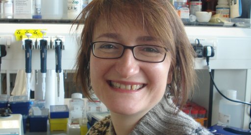 Dr Alison Michie sitting in the lab smiling.