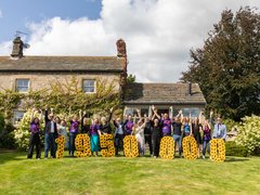 A group of people happy holding up the amount of money raised