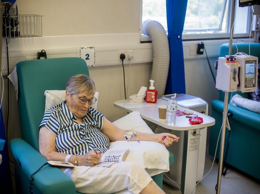 A woman doing a crossword in a day unit