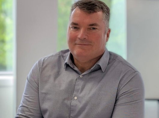 Alastair Boyle seated in an office environment smiling to camera