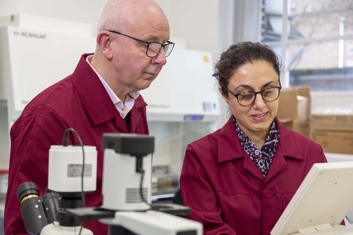 Professor Chris Bunce and a colleague conducting blood cancer research in a laboratory.