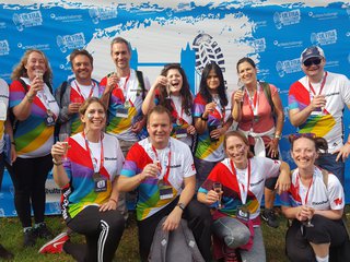 A group of fundraisers each lift a class of champagne after completing the Ultimate Walking Challenge.