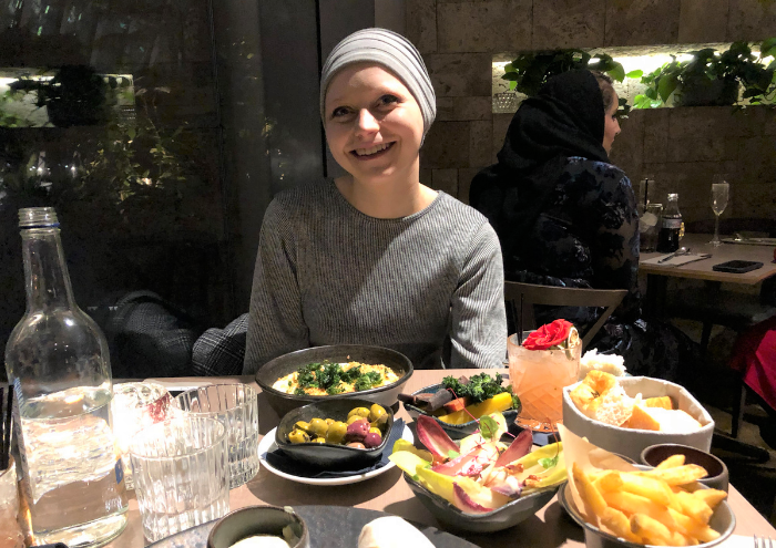 Charlotte at a dinner table with food
