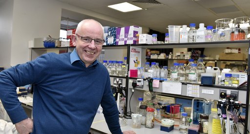 Professor Chris Bunce stood in the lab smiling.
