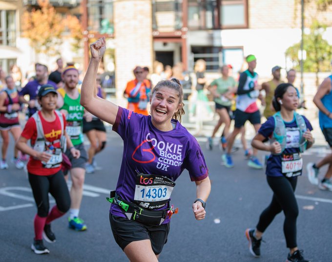 Female Blood Cancer UK runner celebrating with one arm in the air