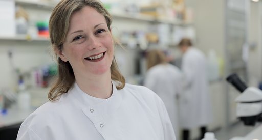 Dr Beth Payne standing in the lab smiling