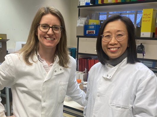 Dr Tracey Chan and Dr Jen Heaney stood in the lab together smiling.