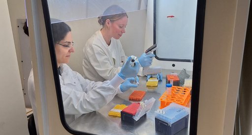 Two ladies wearing white lab coats working in the lab
