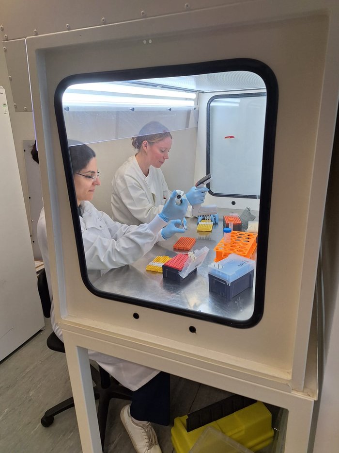 Two ladies wearing white lab coats working in the lab