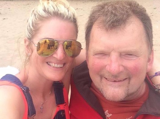 A middle aged couple post together on holiday.