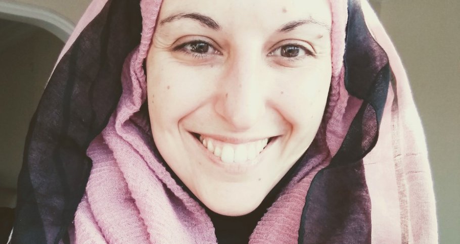 A selfie of a woman (Federica) smiling, wearing a pink and black headscarf