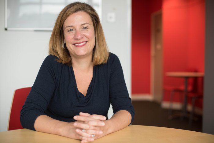 CEO Gemma Peters smiling at her desk