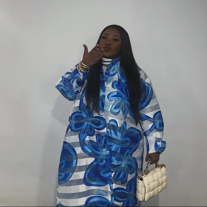 Mphango, beautifully dressed, blows a kiss to the camera.