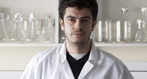A photo of a man in a lab wearing a white lab coat.