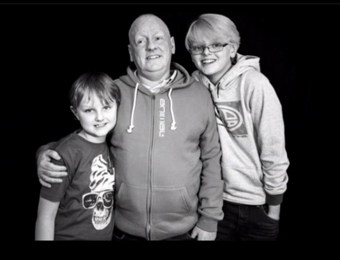 Jake Moules, Blood Cancer UK ambassador, with his brother and stepdad. Black and white photo.