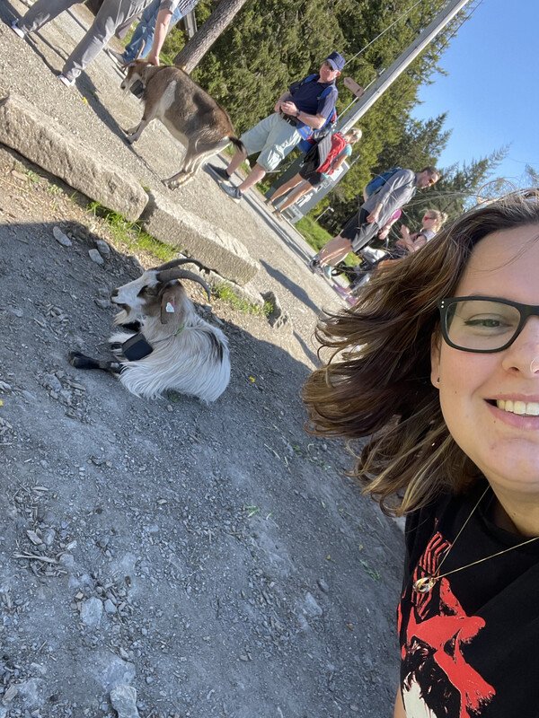 Jess taking a selfie with a goat in the background