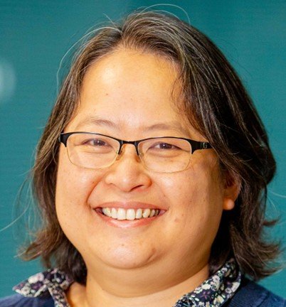 Headshot of a lady with short dark hair wearing glasses and smiling at the camera.