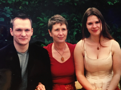 A family photograph of three people - a mother and her two grown-up children.