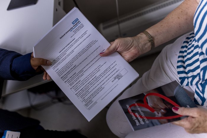 Mock PIS sheet being handed to a patient