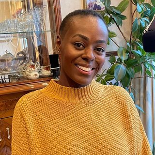 Nadine, wearing a yellow jumper and smiling