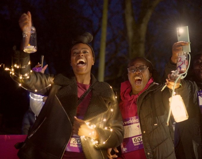Nadine and friend holding lights up and laughing at Walk of Light Birmingham 2024