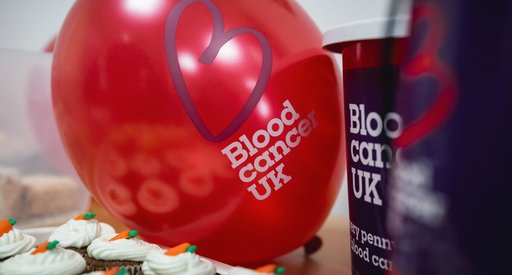 A blood cancer uk branded balloon and cupcakes on a table at a fundraising event.