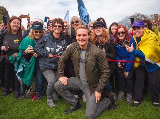 Sam Heughan, President Blood Cancer UK Scotland, poses for a photo in front of a group of My Peak Challenge participants.