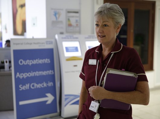 Gill Brisley, lead clinical nurse specialist, carrying a folder at hospital outpatients department in Imperial College, London.