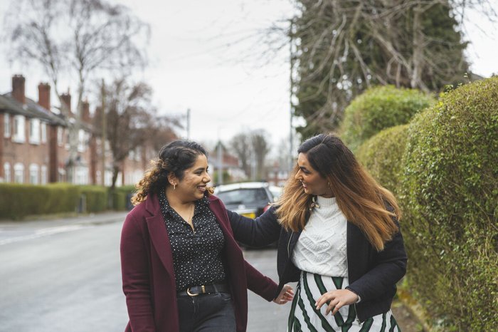 Two friends greeting each other in the street.