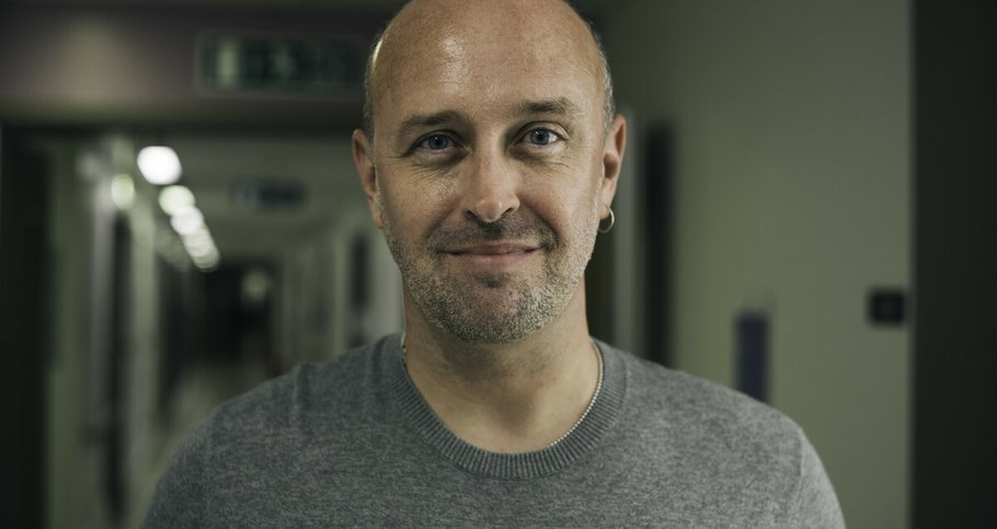 Scott, who has myeloma, standing in a dimly lit hospital corridor