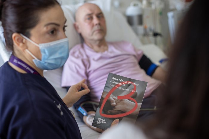 Nurse giving a patient a blood cancer uk flyer