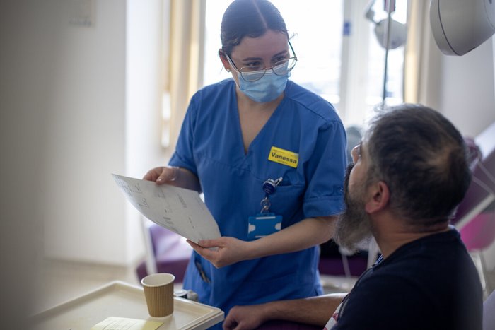 Nurse with a patient in bed, explaining some information