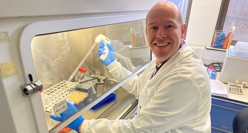 Dr Robbert Hoogeboom smiling sat working in the lab.
