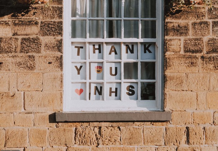 View from outside a window displaying the words 'Thank you NHS' with a heart emoji and a smiley face with heart eyes.