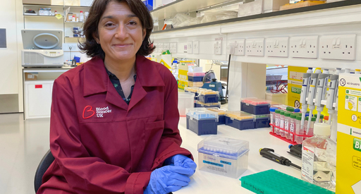 Dr Sara Ghorashain stood in the lab smiling wearing a Blood Cancer UK lab coat.