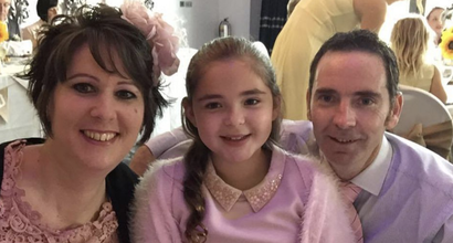 Anna, who was diagnosed with acute myeloid leukaemia (AML), with family at a formal function smiling at the camera.