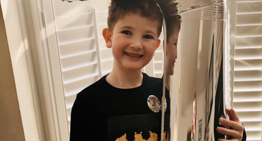 Hugo, who was diagnosed with childhood acute lymphoblastic leukaemia, posing at home with a large helium balloon.