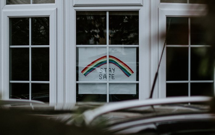 Window with a handmade poster displaying a rainbow with the words 'Stay safe' underneath.