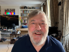 A close up of Stephen Fry at his home, smiling.