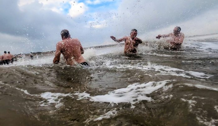 People in the sea fending off waves.
