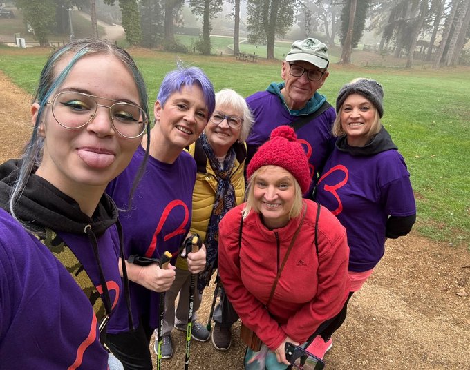Person taking a selfie with loved ones whilst on a walk. All wearing Blood Cancer UK t-shirts