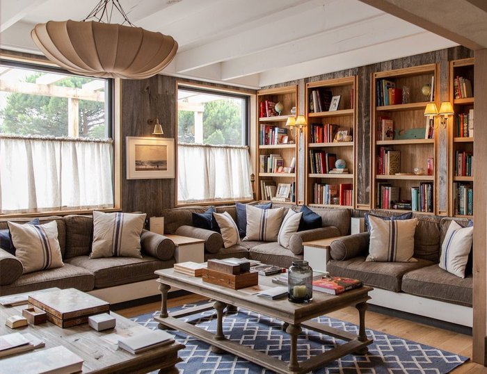 Large, bright, sitting room in the Gallivant with a book wall and comfortable sofas.