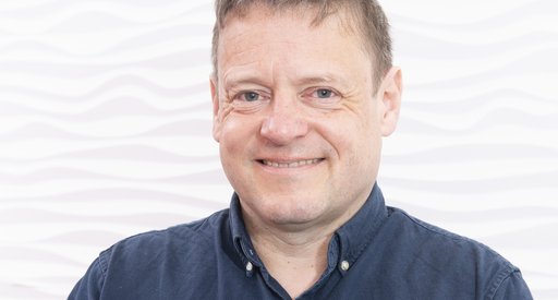 Headshot of Dr Thomas Milne smiling at the camera.