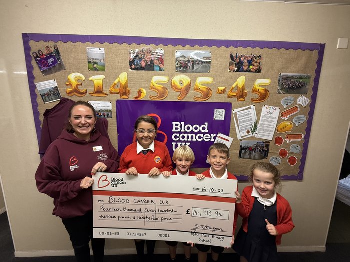 Rhia with children holding a cheque.