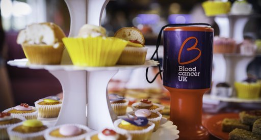 Fundraising pot and cake on a table.