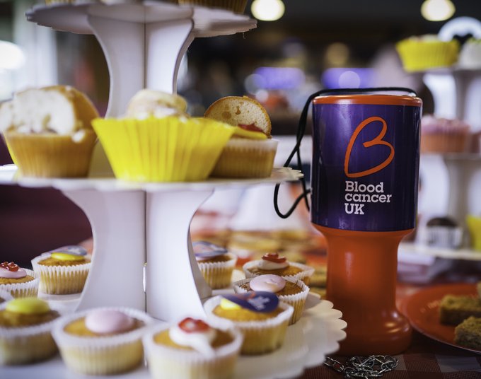 Fundraising pot and cake on a table.