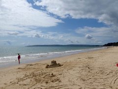 A beach scene with a sandcastle and the sea showing in the background.