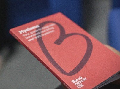A close up of a red booklet about blood cancer. There is the Blood Cancer UK heart logo on the cover.