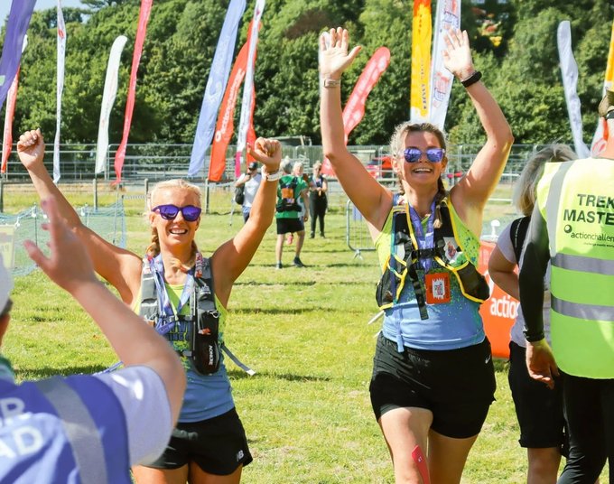 Two walkers taking part in the Peak District Ultra Challenge celebrate their success in the sunshine.