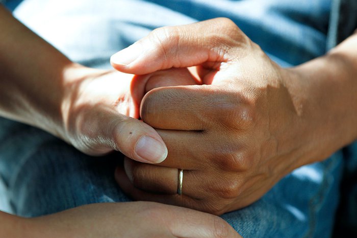 A close up of two people holding hands